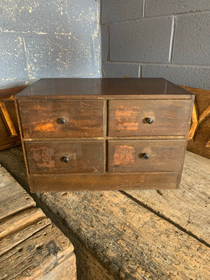 A bank of four wooden collector's drawers