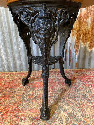 A cast iron Britannia garden table with oak top