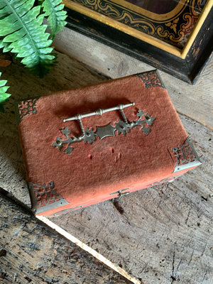 An ornate red velvet sewing box