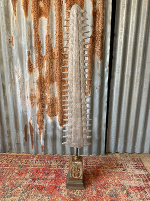 A very large cast metal sawfish bill on stand