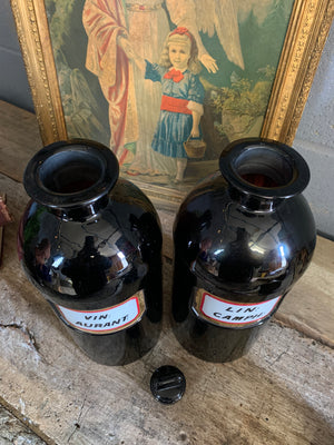 A pair of very large amethyst glass apothecary bottles