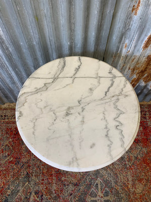 A black cast iron bistro table with marble top