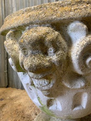A very large urn with jester head detailing