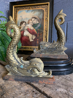 A pair of dolphin motif brass and cast iron doorstops