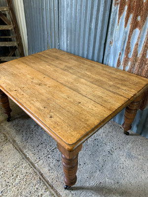 A Victorian scrubbed pine kitchen or dining table on castors