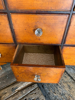 A bank of wooden apothecary drawers