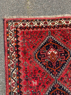 A red ground Persian rectangular rug with double diamond design- 158cm x 111cm