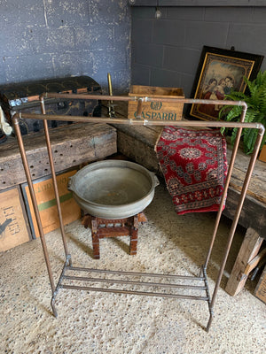 A vintage industrial copper pipe double clothing rack