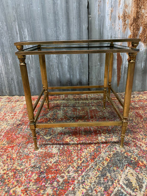 A brass and glass Hollywood Regency nesting pair of tables
