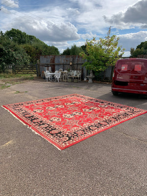 A very large hand woven Persian red ground rug - over 12ft