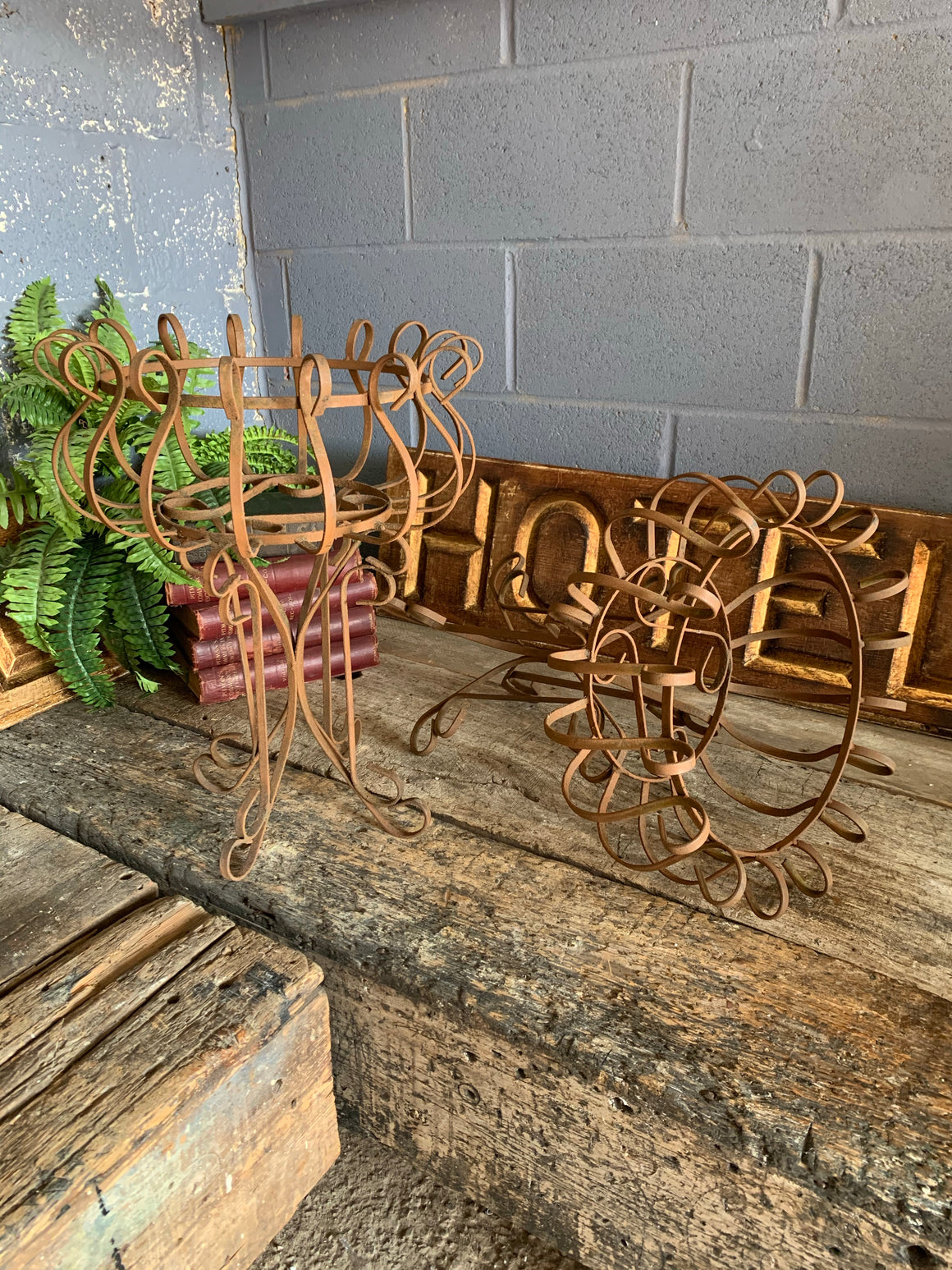 A pair of rusty wrought iron plant stands