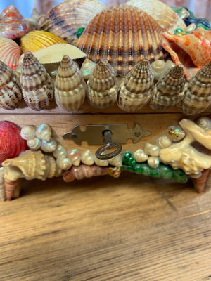 A seashell encrusted trinket box with key