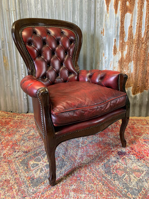 A red leather button back armchair