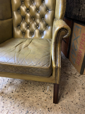 An apple-green wingback Chesterfield chair