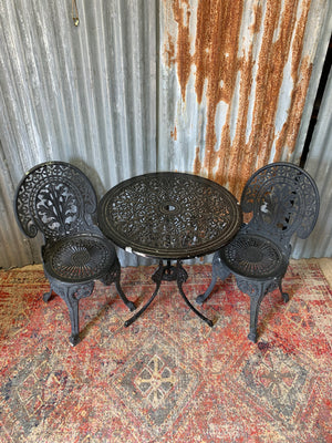 A black cast metal garden table and two chairs