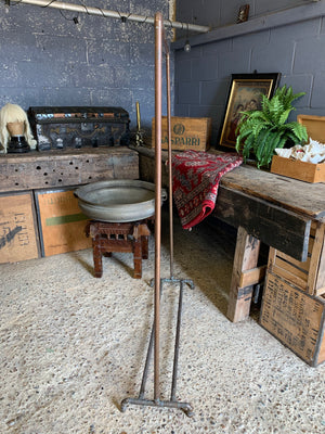 A vintage industrial copper pipe clothing rack