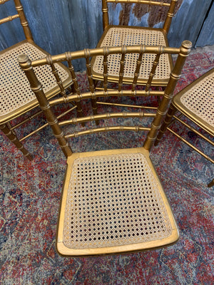 A set of four faux bamboo chairs with cane seats