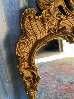 A large Rococo style cast iron mirror