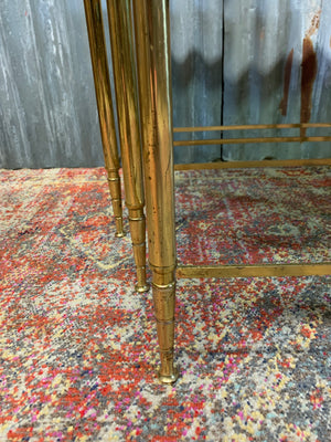 A brass and glass Hollywood Regency nest of three tables