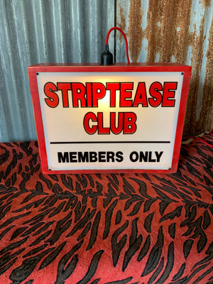 A striptease club illuminated light box advertising sign