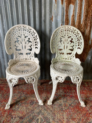 A white Victorian style table and two chairs garden set