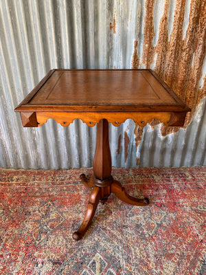 A leather-topped square occasional table