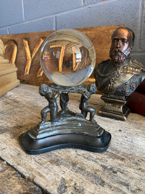 A fortune teller's crystal ball on a bronze and marble stand