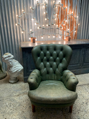 A small green leather Chesterfield armchair