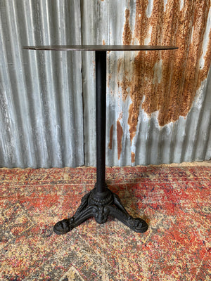 A black cast iron circular bistro table