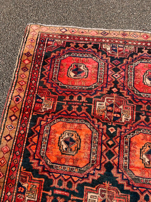 A large red ground Bokhara Persian rug with 'elephant foot' design
