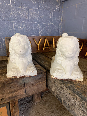 A pair of white cast stone lion and ram statues