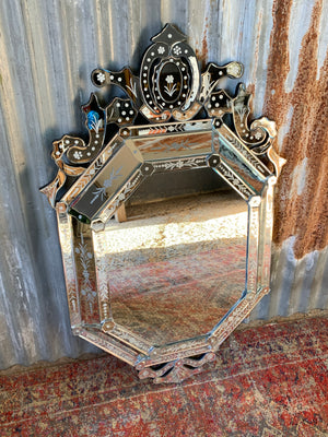 A large Venetian style cushion mirror