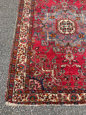 A large hand woven Persian red ground rectangular rug with bird motifs