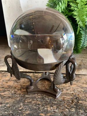 A large fortune teller's crystal ball on a bronze stand