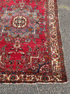 A large hand woven Persian red ground rectangular rug with bird motifs