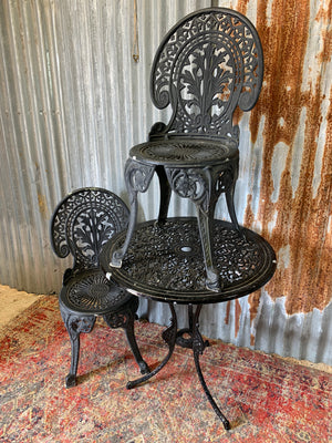 A black cast metal garden table and two chairs