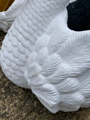 A pair of cast stone planters in the form of swans
