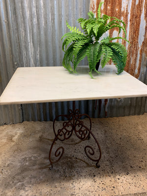 A cast iron garden table with marble top