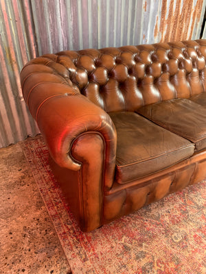 A brown three seater Chesterfield sofa with button back