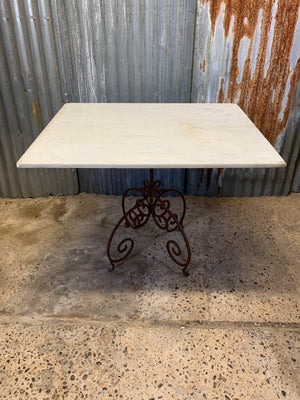 A cast iron garden table with marble top