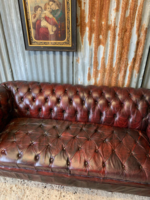 An oxblood three seater Chesterfield sofa with button back and seat