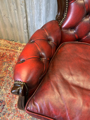 A red leather button back armchair