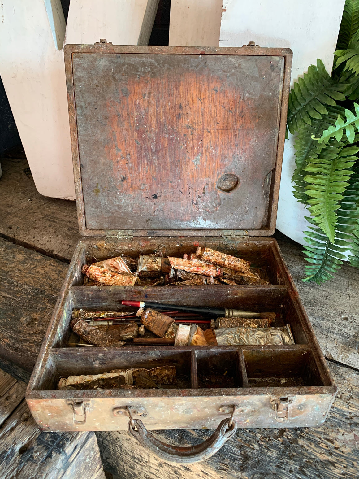 A wooden artist's box with palettes, brushes and paints by C. Roberson