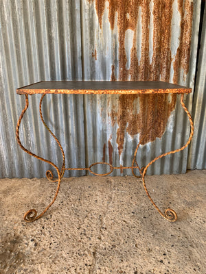 A twisted wrought iron garden table