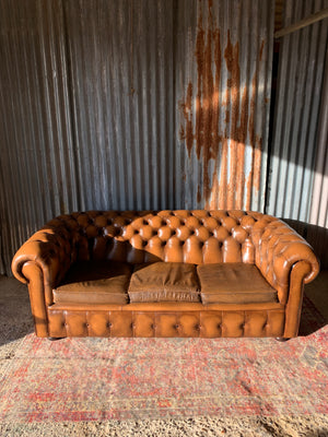 A brown three seater Chesterfield sofa with button back