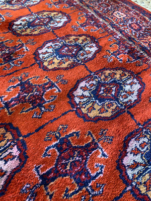 A Persian orange-red ground rectangular rug with multiple lozenge