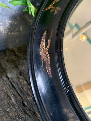 An oval black lacquered Chinoiserie mirror