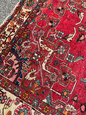 A large hand woven Persian red ground rectangular rug with bird motifs