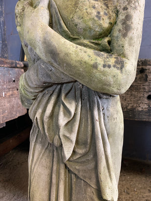 A large cast stone statue of Pandora