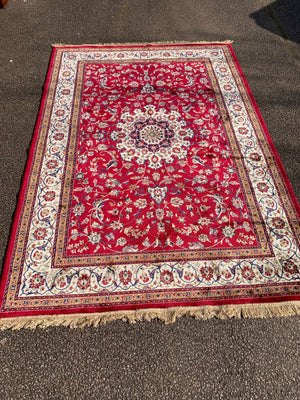 A large red ground Persian rectangular rug